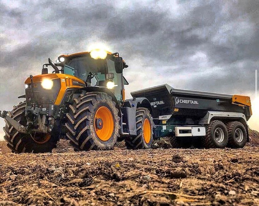 Chieftain HP20 high-speed dump trailer pulled by an orange tractor on a field